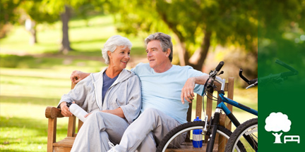 Älteres Paar auf Parkbank davor ein Fahrrad