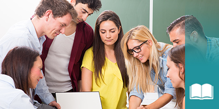 Gruppe von jungen erwachsenen Schülern steht um einen Bildschirm im Hintergrund Tafel